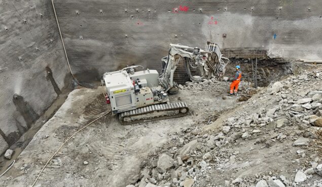 Bauarbeiter überwacht Baggerarbeiten auf Baustelle